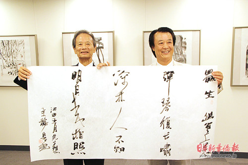 日中友好会馆会长江田五月和著名画家巨石一起展示书法作品。(日本《新华侨报》)