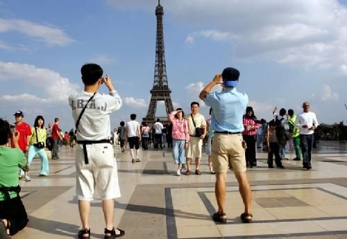 中国游客在艾菲尔塔前留影纪念。（法国欧洲时报网）
