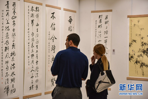 10月27日,在泰国曼谷中国文化中心,两名观众在庆祝泰中建交40周年中国名家书画展上欣赏书画作品。(李芒茫