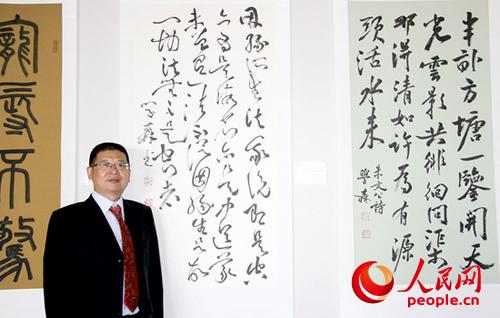 何学森教授和他展出的部分书法作品。(马小龙