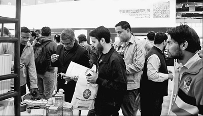 在新德里世界图书博览会中国主宾国展台，印度读者边看书边品茶。（邹松