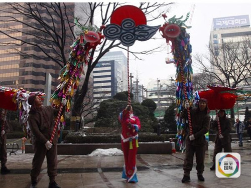 1月26日，在韩国首尔闹市区，来自湖北十堰的民间艺人表演凤凰灯舞
