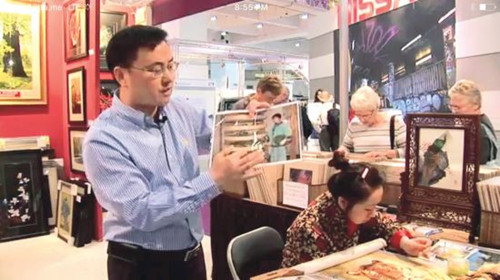 飞哥在英国伦敦展销会现场,向英国媒体介绍苏绣