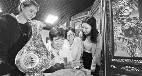 5月10日,观众在观看工匠技师雕刻雕漆礼盒(贺勇