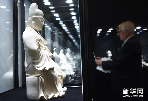 5月26日,观众在拍摄一尊德化窑人物塑像(罗晓光