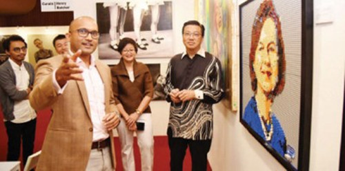廖中莱（右起）在周美芬的陪同下，参观艺术展（马来西亚《光华日报》）