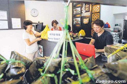 和记肉粽去年底设立网站让顾客上网预订粽子,少东周崇青(右)希望通过这项服务吸引年轻顾客群(新加坡《联合早报》/谢智扬