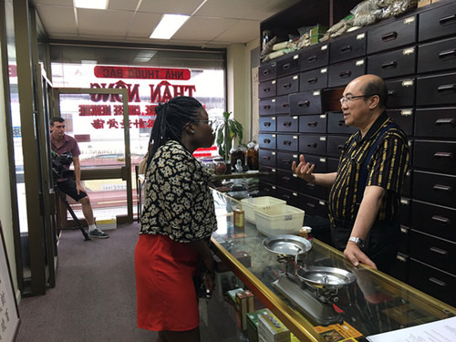澳洲全国中医药针灸学会联合会会长林子强(右)向访客介绍(澳大利亚《澳洲网》)