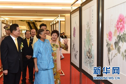 6月26日,在泰国曼谷,泰国诗琳通公主(前排中)在中国驻泰国大使宁赋魁(前排左)和夫人初庆玲女士(前排右)的陪同下观看“宁赋魁大使及夫人初庆玲女士曼谷王朝宫廷服装摄影及中国画作品慈善展览”。(李芒茫