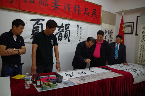 李兆银挥笔写字。(美国《世界日报》/金春香