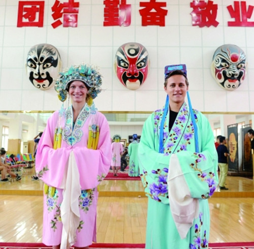 德国大学生斯特凡·格拉丁格尔（右）与同学在山东省京剧院试穿京剧演出服装。(苏锐