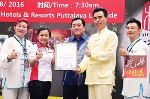 李佩玲（左2）颁发《大马纪录大全》予何俊龙（左4），并由黄家泉（中）见证。(马来西亚《光华日报》)