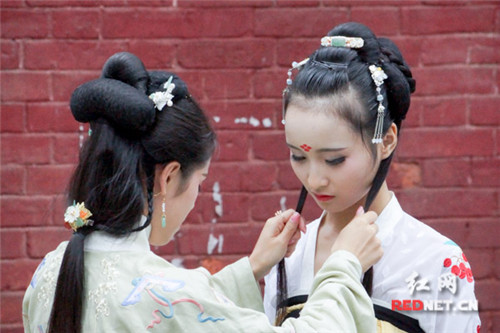 司徒漪澜(陈佳鑫)给好友晓丹整理妆容。(赵毅旻