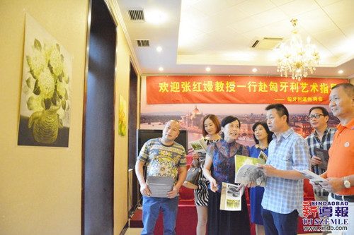张红嫚(左三)在交流会上为匈牙利侨胞们讲解她的作品。(匈牙利《新导报》/金晓晓