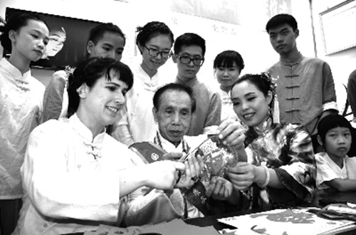 心一(前排左一)与饶宝莲(前排左三)在交流剪纸艺术