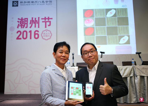 潮州八邑会馆会长郭明忠(左)和潮州节筹委会主席林雍杰所展示的手机游戏“Heng