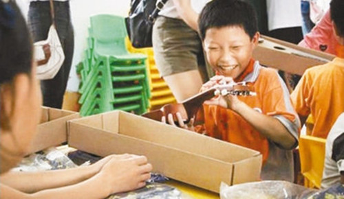 在广东省保利地产和谐文化基金会举办的公益活动中,从化市石明小学的同学领到了崭新的乐器。(资料图片)