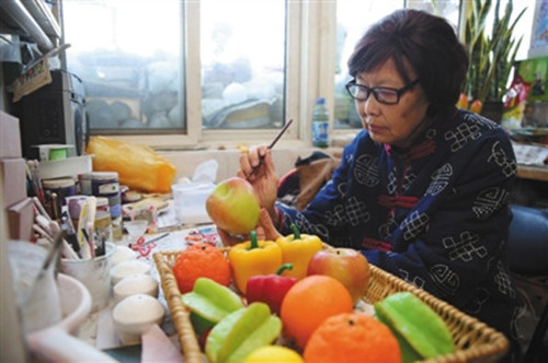 23日，西城区非物质文化遗产蜡果制作传承人刘秀华的家中，刘秀华正在制作水果蔬菜。(李飞