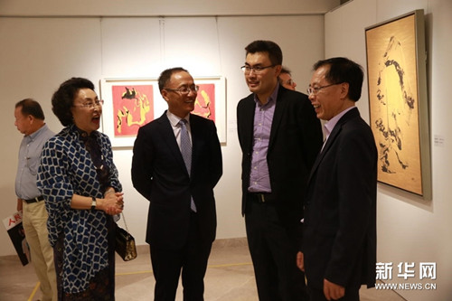 中国侨网11月27日，“赵莉诗意抽象派油画展”在新加坡举行。图为诗意抽象派油画画家赵莉（左一）为中国驻新加坡大使陈晓东（左二）、中国驻新加坡大使馆文化参赞肖江华（右一）介绍画展情况。