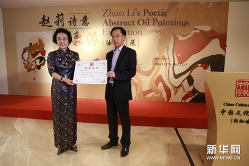 中国侨网11月27日,“赵莉诗意抽象派油画展”在新加坡举行。赵莉曾应中国文化部邀请,为新加坡中国文化中心的落成创作并捐赠了巨幅油画《乡梦》。图为肖江华为赵莉颁发了捐赠证书。