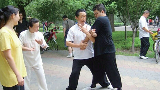 中国侨网2011年8月，高继武在北京官园公园向杨希龙传授八卦掌七十二招。（《欧洲时报》/晓明 摄）