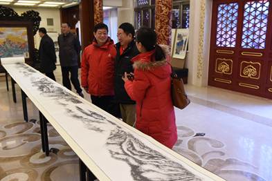 中国侨网周鸿儒先生为观众讲解用中国水墨画法绘制的美国大峡谷长卷