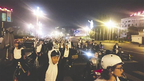 中国侨网“周五夜骑团”身穿熊猫装骑行在成都街头。(资料图)