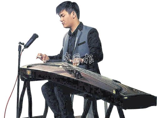 中国侨网陈劲隆在表演时全神关注，带领听众进入古筝的世界。(马来西亚《中国报》资料图)