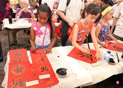 中国侨网杜若（左一）学习书法两年，她参加在新加坡书法中心举行的全国挥春大会，下足心思写了副春联。（新加坡《联合早报》 周柏荣摄）