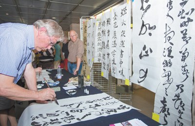 中国侨网日内瓦大学孔子学院举办的中国书法展示活动上,一位当地汉语爱好者展示书法技艺。