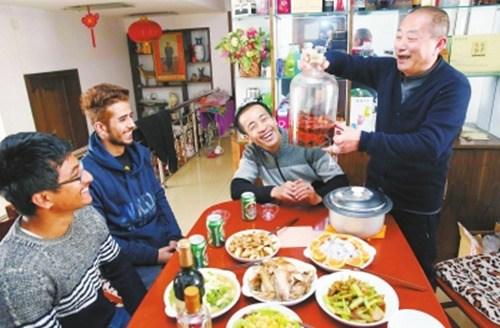 中国侨网热情的漯河人拿出自制的酒，款待外国友人。(刘广超 摄)