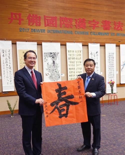中国侨网洪磊总领事(左)写“春”字请屠新时会长向丹佛华人问候。