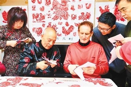 中国侨网德雷克向魏永信学剪纸。(黄亚平 摄）