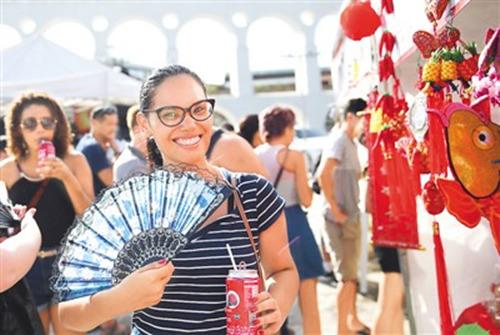 中国侨网1月28日,“欢乐春节”系列活动在巴西里约热内卢市拉帕景区继续进行。拉帕广场上摆起中国小吃、书法等摊位,俨然一场“中国庙会”,吸引了不少里约当地人前来感受中国文化。图为一名巴西人在拉帕景区展示刚刚购买的扇子。新华社记者 李明 摄