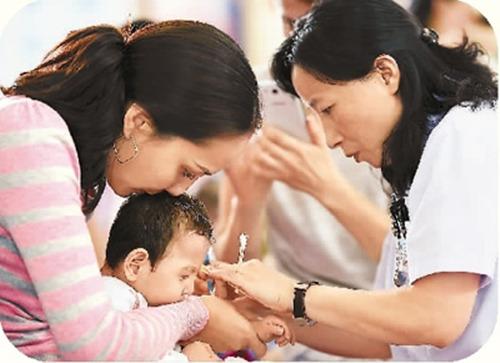 中国侨网2016年9月19日，在黑龙江中医大二院的康复中心，来自哈萨克斯坦的热尼娜抱着孩子阿尔斯兰接受中医康复治疗。(新华社记者 王建威 摄) 