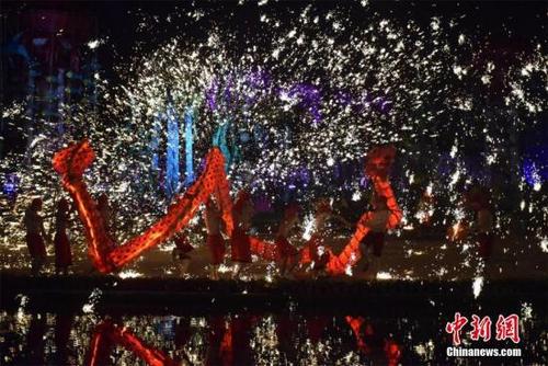 中国侨网2月4日晚,国家级非物质文化遗产“火龙钢花”亮相武汉欢乐谷,上演“人在龙中舞,龙在火中飞”的奇观。马芙蓉 摄