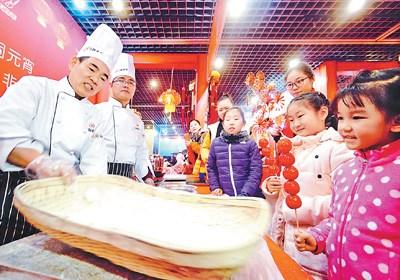 中国侨网图为庙会工作人员展示传统元宵制作工艺。  　本报记者  贺勇摄