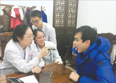 中国侨网严利依(中)跟随北京中医药大学博导谷晓红教授(左一)在国医堂出门诊。(马雪颜 摄)