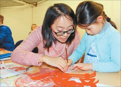 中国侨网一名比利时小女孩在中国老师的指导下学习剪纸。(任彦 摄) 