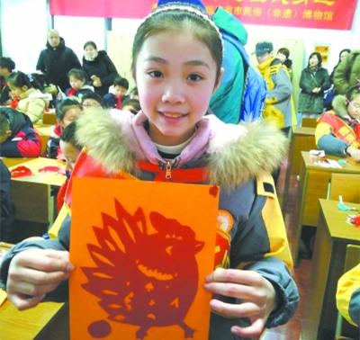 中国侨网孩子开心地展示自己的剪纸作品