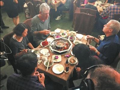 中国侨网美国CNN美食“大魔王”波登请米其林三星大厨艾瑞克（右一）吃四川火锅，艾瑞克直言辣得眼睛都歪了。