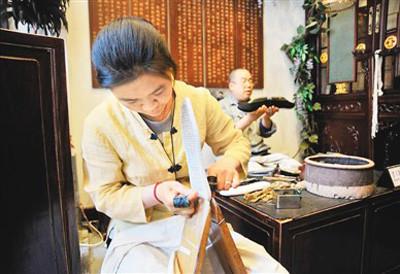 中国侨网一双一字纳底,每平方寸纳八十一针以上,每双鞋要纳超过二千一百多针。图为内联升工匠在纳底(制作鞋底)。(资料图片)