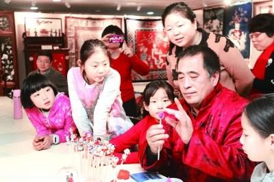 中国侨网非遗传承人高继泽教孩子们捏面塑。
