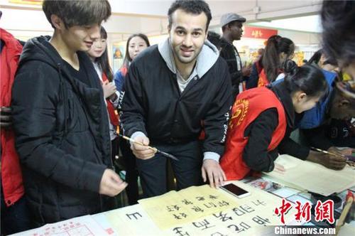 中国侨网留学生写书法。(汤雨馨 摄)