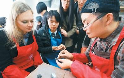 中国侨网图为来自俄罗斯的留学生在周宝康(右)指导下学习制作泥叫叫。  杨 雨 摄(人民视觉)