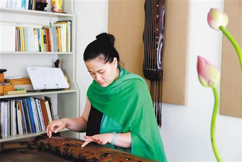中国侨网巫娜在弹奏古琴。