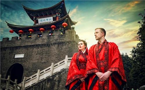 中国侨网在夕阳下的古佛寺前，克里斯和吉玛身着朱红色宽袍广袖的汉服幸福地依偎在一起。（新华网摘自网络图片）