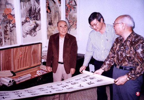 中国侨网袖海楼主人杨启霖（左）请中国鉴定家杨仁恺（右）到家中品鉴藏画。(新加坡《联合早报》资料图)