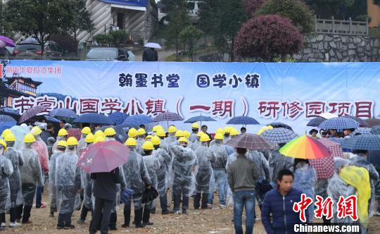 中国侨网众人雨中参加国学小镇的开建仪式。　杨华峰　摄