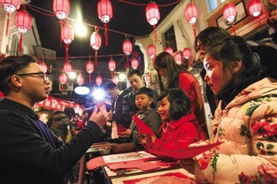 中国侨网在市区朔门街，朱铭教孩子们剪窗花。